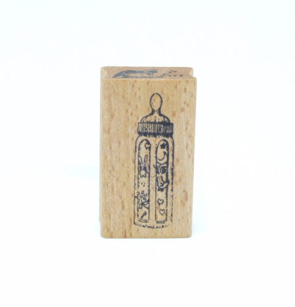 Holzstempel mit dem Motiv einer Babyflasche